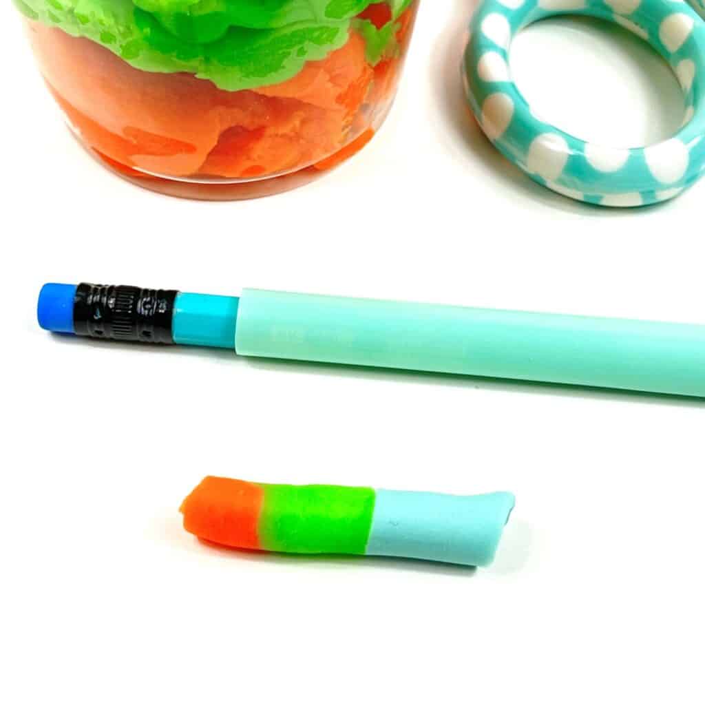 Taking a core sample of the Play-Doh layers using a straw.