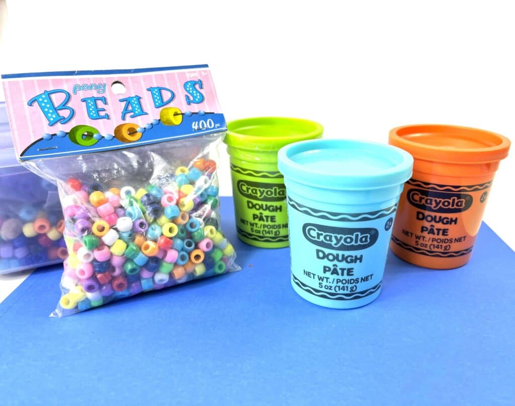 Play-Doh and colored beads to make models of the geologic time scale in a cup.