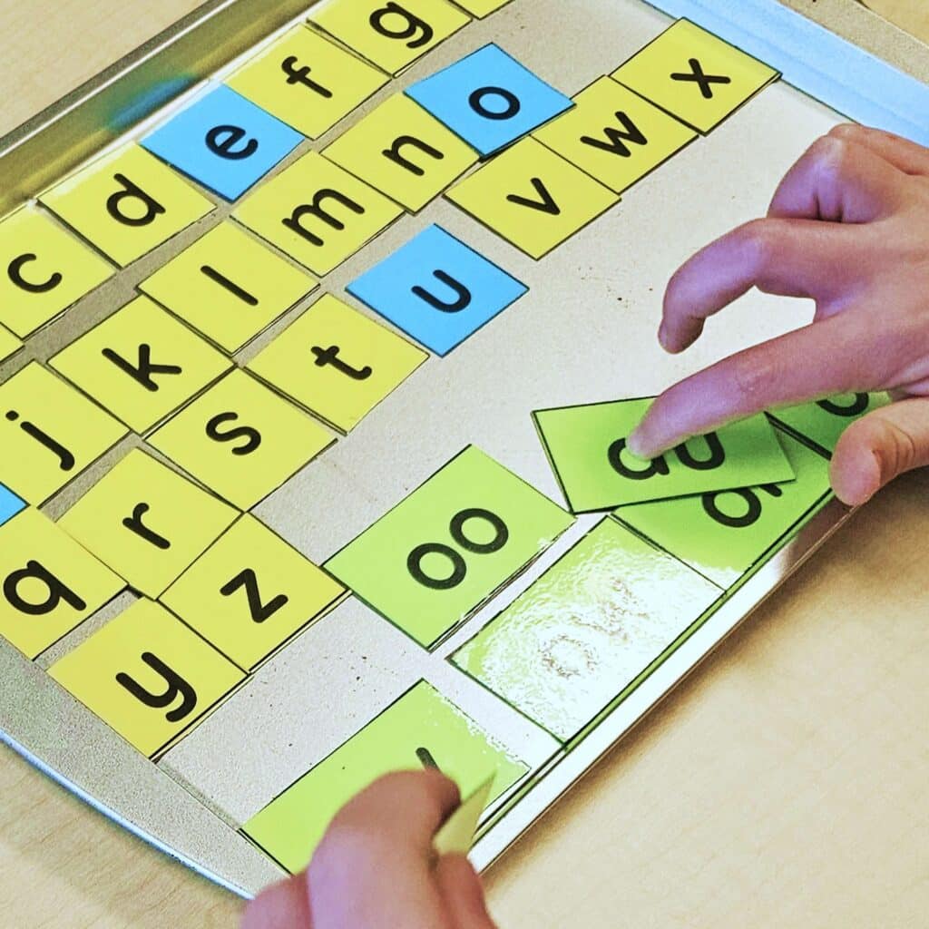 Phonics letter cards and phonics pattern cards on a cookie sheet.