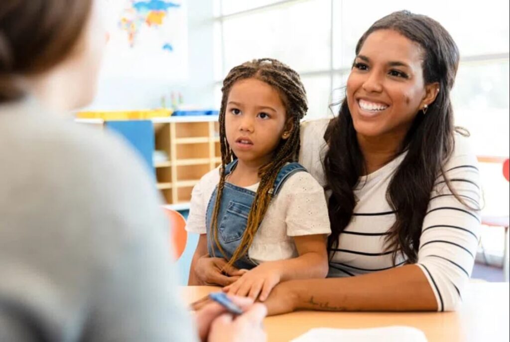 A teacher having a conference with a parent in an article for teachers about ways to be proactive with parents.